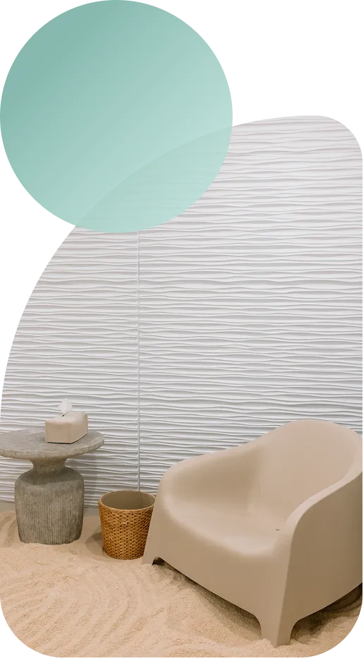 A calming Breathe Salt Rooms salt therapy room with a comfortable chair beside a textured salt wall.