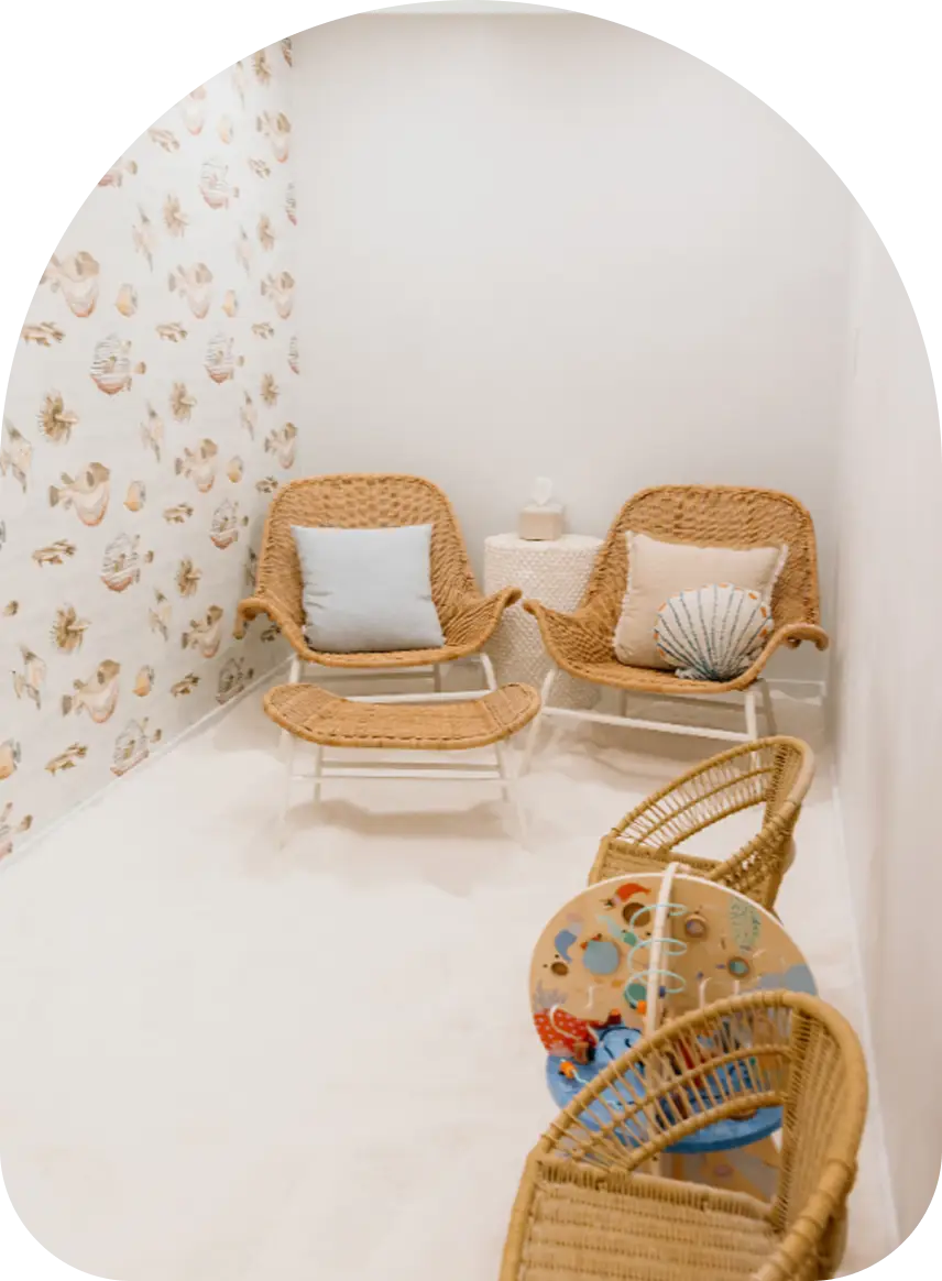 Two wicker lounge chairs with cushions in the children’s Sea Salt Room.