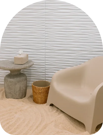 A white lounge chair and ottoman positioned next to a warm, backlit Himalayan salt wall.