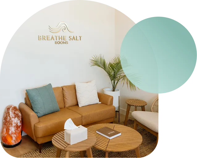 A warm, softly lit salt therapy lounge with a comfortable couch and cushions.