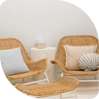 A white lounge chair and ottoman positioned next to a warm, backlit Himalayan salt wall.