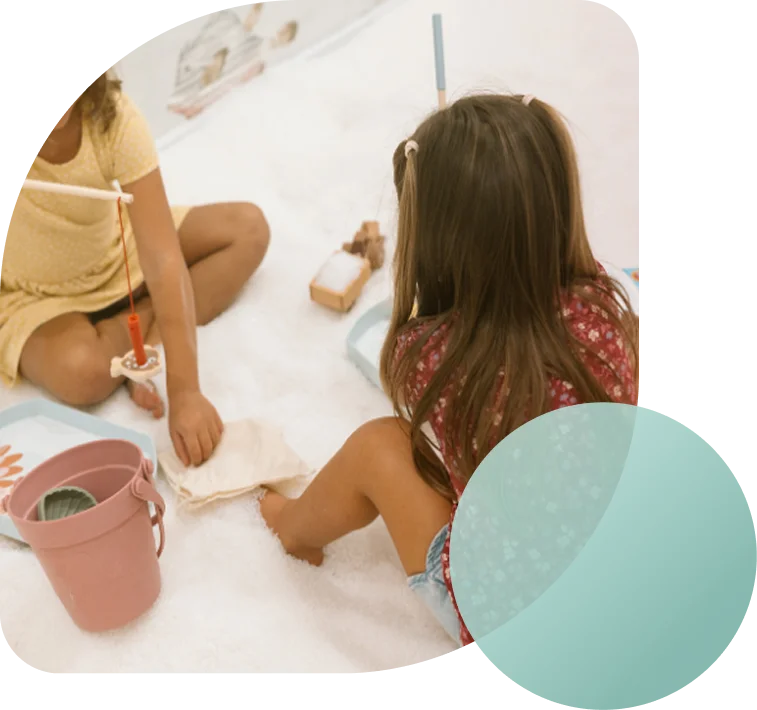 Two young children playing with toy fishing rods and buckets in a white salt therapy room at Breathe Salt.